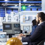 Specialist in solar panel manufacturing facility analyzing production metrics